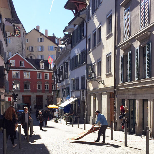 Nomadenschaetze: Fidel elegantly swinging a new production kilim to have it photographed on the ground